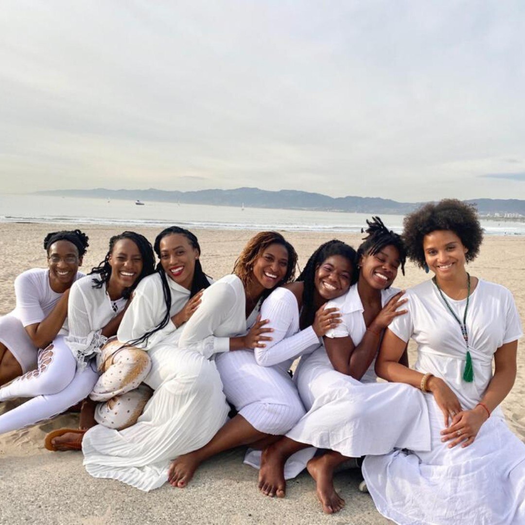 A group in white on the beach with Koya Webb
